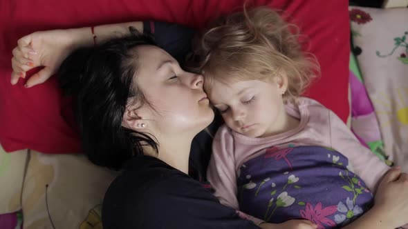 Sleepy Young Woman with Her Baby Does Not Want To Wake Up in the Morning