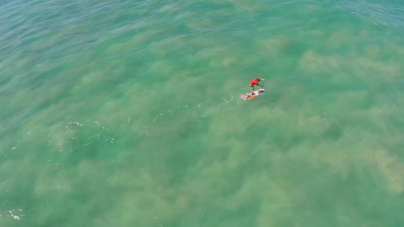 Aerial view of a man sup stand-up paddleboard surfing in Waimea, Hawaii