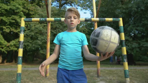 Self-Confident Boy Footballer With Ball Looking at Camera, Welcoming for Match