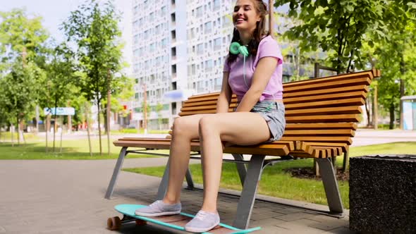 Happy Teenage Girl with Headphones and Longboard