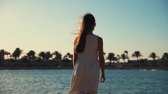 Young Female Model with Long Hair Enjoying Summer at Beautiful Sand Coastline.