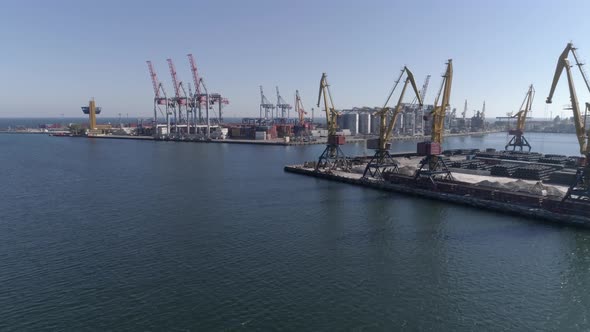 Sea Industry, Commercial Berth with Containers and Lifting Cranes on Sea Coast Against Blue Sky 