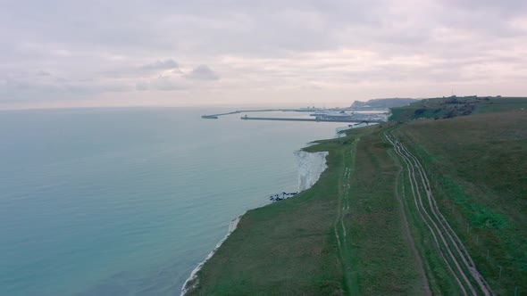 Aerial drone shot of pathways ontop of white cliffs of dover towards dover harbour