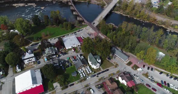 A steep high flyover view looking down on the small town of Ohiopyle, Pennsylvania in early autumn.