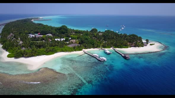 Aerial flying over panorama of beautiful coastline beach break by transparent ocean and white sand b