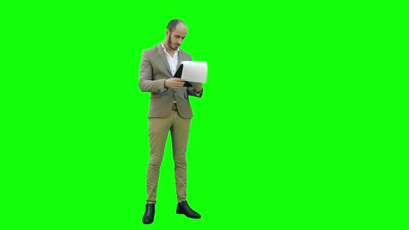 Concentrated Businessman Reading Important Report on a Green Screen, Chroma Key