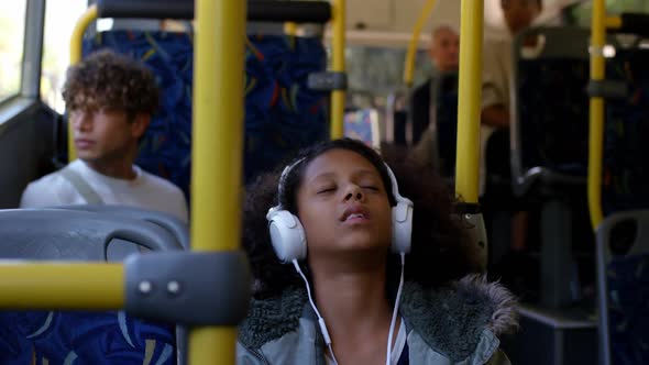 Girl listening music on headphones while travelling in bus 4k