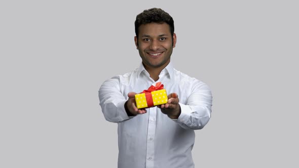 Portrait of Happy Hindu Man Giving Gift Box To You
