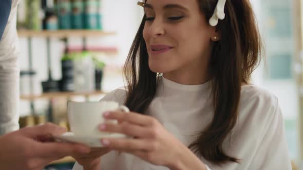 Handheld view of beautiful woman drinking coffee in hair salon. Shot with RED helium camera 