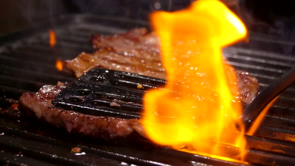 Cook Presses the Steak on the Grill Grate