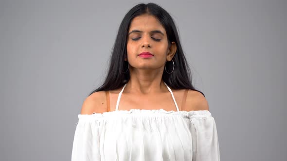 A beautiful and attractive Indian girl doing yoga and mediation by taking deep breaths