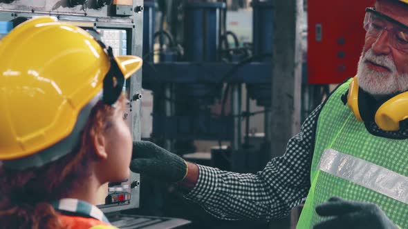 Group of Factory Workers Using Machine Equipment in Factory Workshop