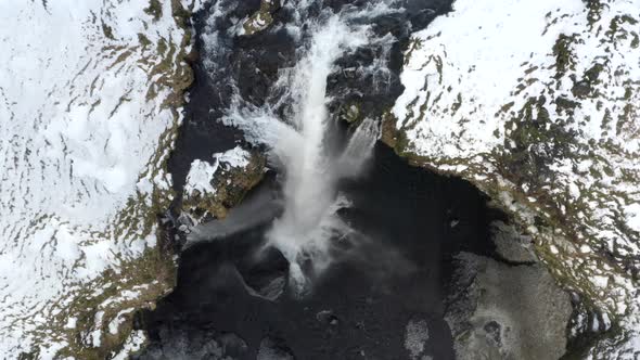 AERIAL: Close Up of Waterfall in Snow, Ice Canyon in Iceland Green Grass, Cloudy
