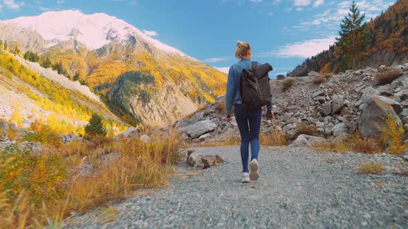 A young beautiful slender woman alone in the mountains.