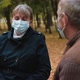 Senior Grandparents Couple in Medical Masks Sitting in Park - VideoHive Item for Sale