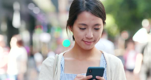 Woman check on cellphone at street