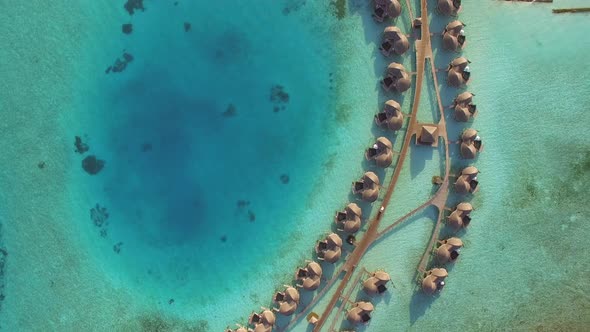 Aerial view above a group of bungalows in a luxury resort, Maldives island.