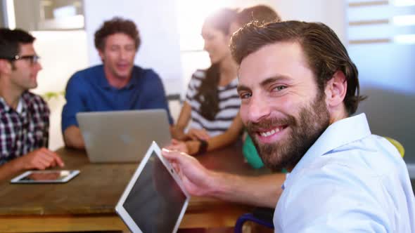 Business people discussing over digital tablet and laptop