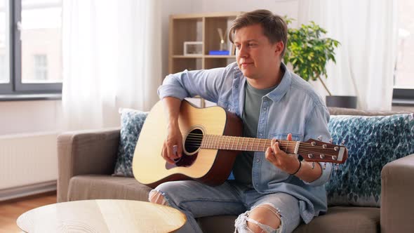 Young Man Playing Guitar at Home