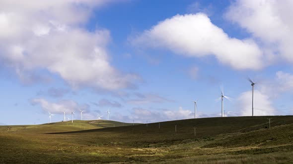 Time lapse of wind turbines in remote landscape area during daytime with passing clouds in Ireland. alt