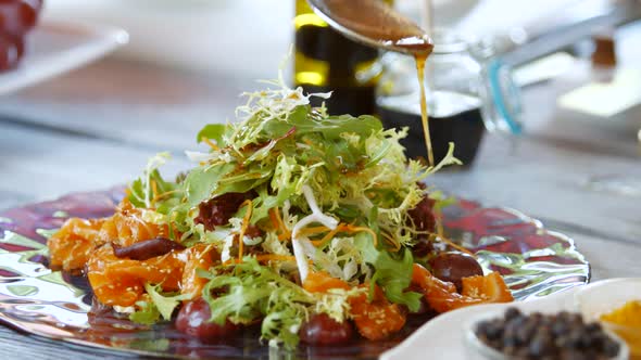 Spoon Pours Liquid on Salad.