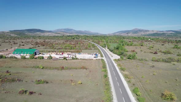 Empty Asphalt Road on the Plateau Between Green Fields Highland Way Aerial View