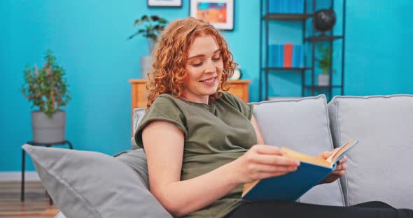 A Beautiful Pregnant Woman Spends Her Free Time Reading a Comedy Book Laughing Turning the