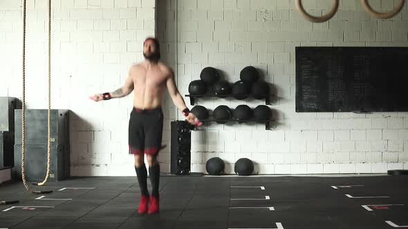 Active man skipping rope in gym