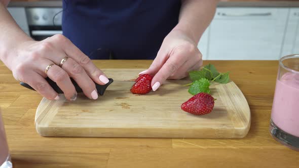 Cuts Strawberries to Decorate the Dessert