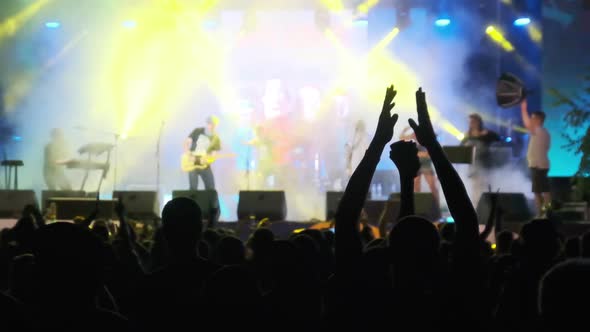 Crowd of Fans at Live Rock Concert Raise Hands and Dance. Slow Motion 240 Fps