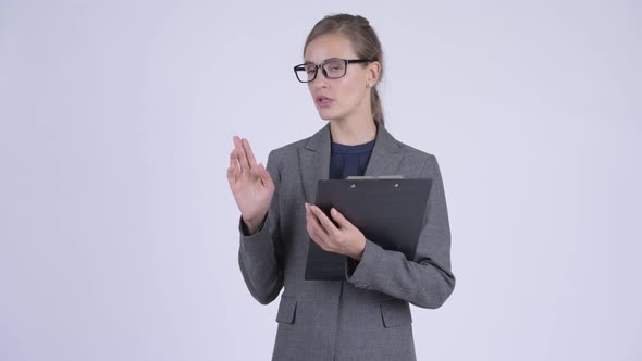Young Beautiful Businesswoman Talking While Holding Clipboard