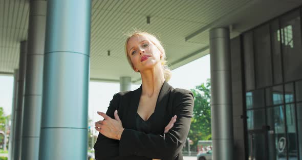 Formally Dressed American Business Woman Looking Into the Camera with Her Arms Crossed While