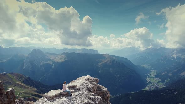 Flying Backward Over Woman Sitting on the Top of Piz Boe Mountain in Dolomites