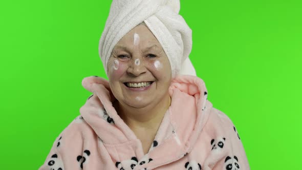 Elderly Grandmother After Shower. Old Senior Woman with Moisturizing Cream Jar