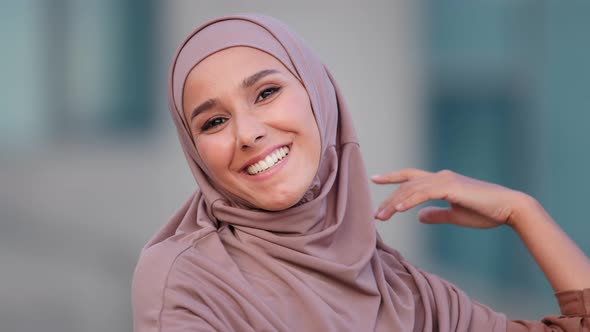 Portrait of Beautiful Young Arab Muslim Woman in Traditional Hijab Dancing in City Smiling