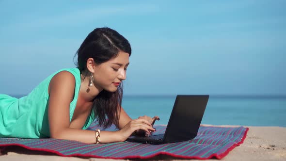 Pretty Young Woman Using Laptop on Beautiful Tropical Beach