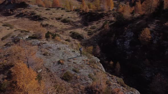 Hiker with back standing in the mountains looking at view