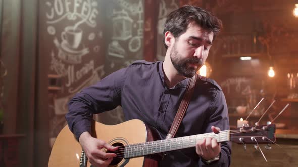 Man Passionately Performing a Composition on an Acoustic Guitar