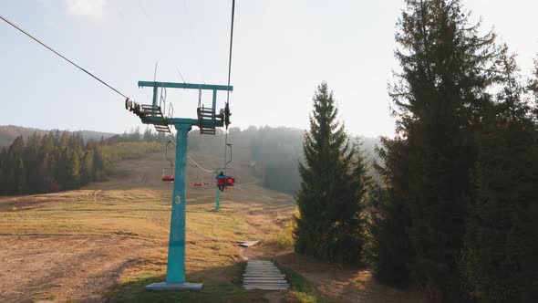 A Man Rides a Ski Lift in Autumn