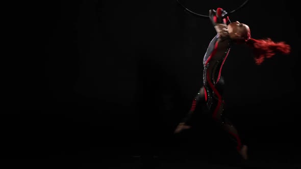 Flexible Slim Young Woman in Stage Costume Spinning in Slow Motion Holding on Air Hoop with Hands