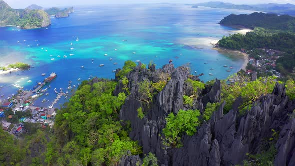 Man and Woman Standing on a Rocky Top of the Mountain Overlooking the Port and the Blue Sea Lagoon