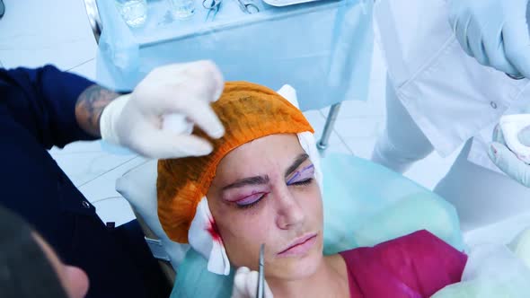 The Surgeon Sutures the Patient's Eyelids