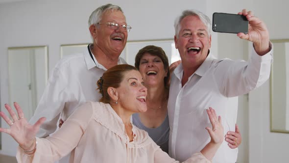 Caucasian senior couple spending time together in a ballroom taking a selfie