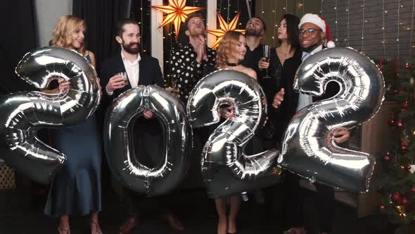 Group of Friends Holding Inflatable Foil Numerals 2022