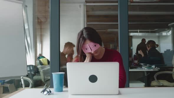 Inefficient Tired Female Employee Pretends Working Sleeping with Stickers on Face Sits at Desk