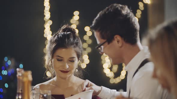 Close Shot of Portraits of Young Couple Talking at Table During Holiday