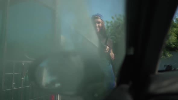 Car Side Window Closed with Woman Spraying Water with High Pressure Washer in Slow Motion