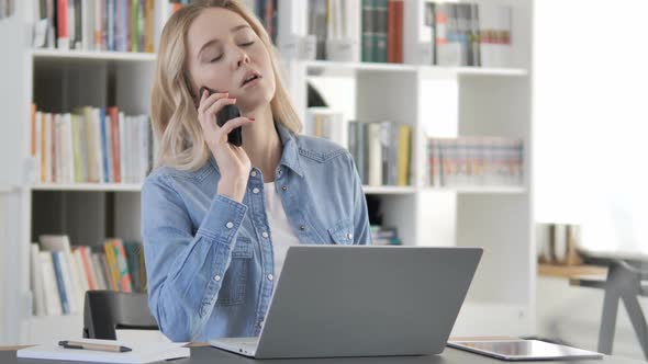 Young Woman Talking on Phone at Work