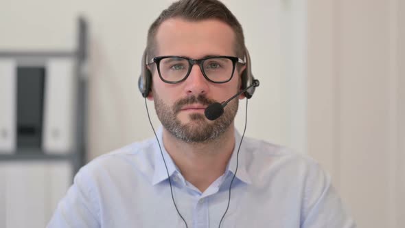 Portrait of Middle Aged Man with Headset Looking at the Camera