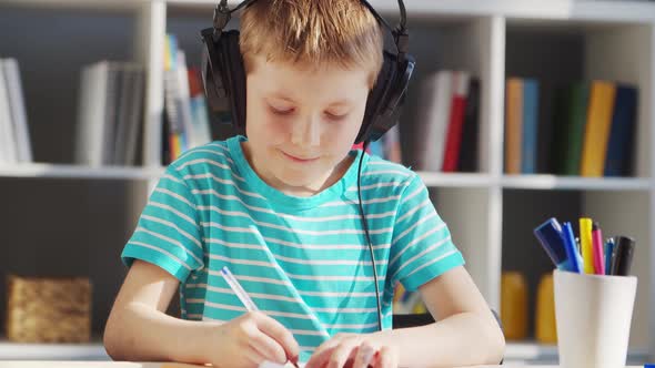 Boy is Doing  Homework at the Table. Cute Child is Learning at Home.